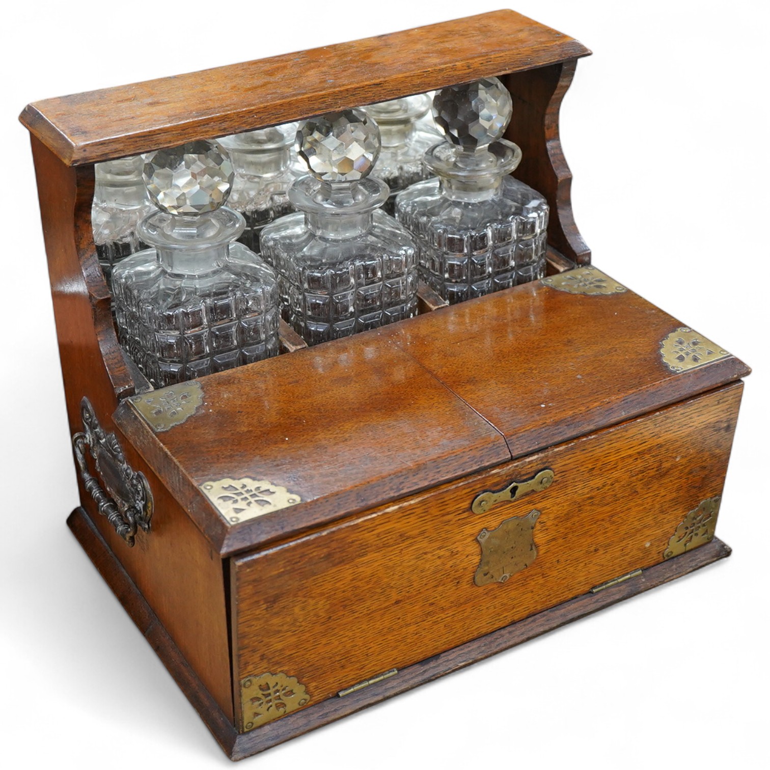 A Victorian oak three-bottle tantalus, with compartment for glasses, 30cm high x 34cm wide